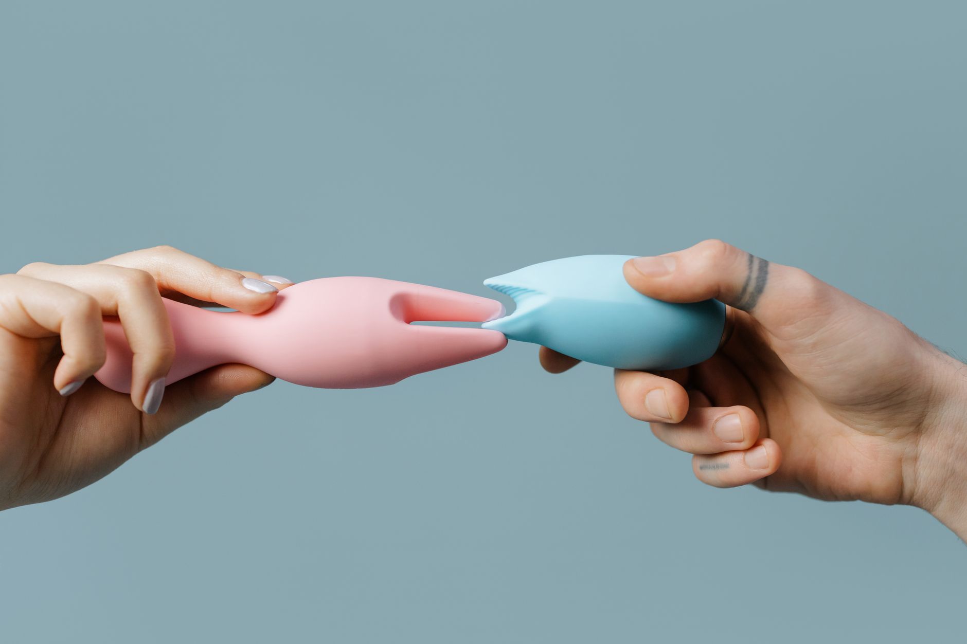 A blue silicone vibrator held in hand, symbolizing gentle exploration of clitoral sensation and self-discovery