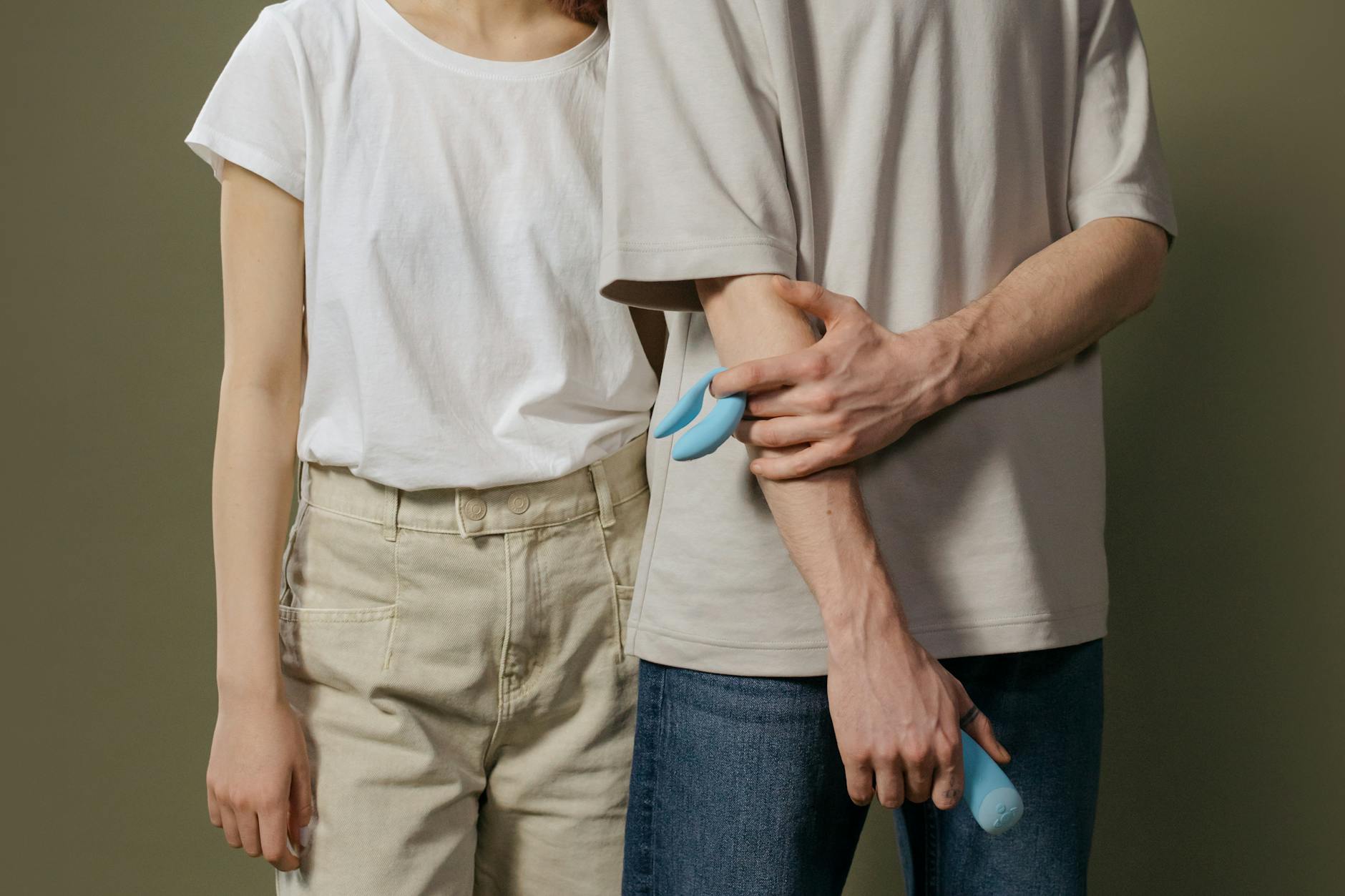 A couple holding a modern vibrator together, representing intimacy during hormonal transitions